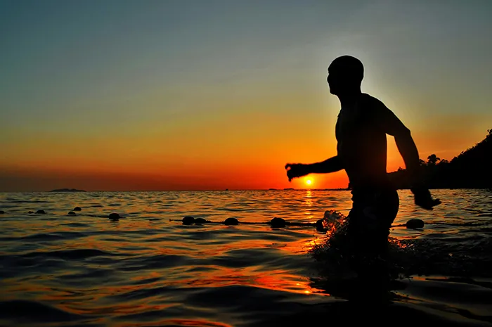 hombre entrando en el mar